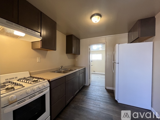 A kitchen with a white stove and a white refrigerator.