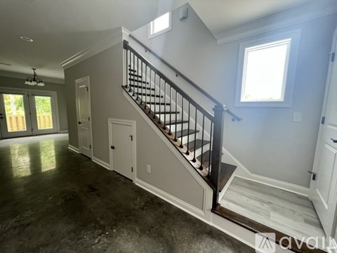 A spacious room with a staircase leading to the upper floor.
