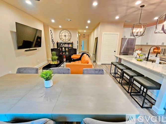 A modern living room with a grey table and a television on the wall.