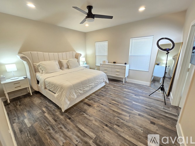 A bedroom with a large bed and wooden flooring.