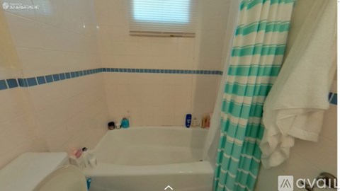 A bathroom with a white tub and a striped shower curtain.
