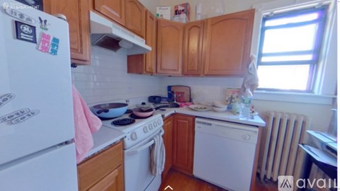 A kitchen with a white fridge and wooden cabinets.
