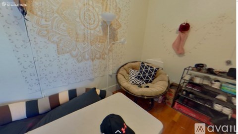 A cat bed sits in the corner of a room with a patterned wallpaper.