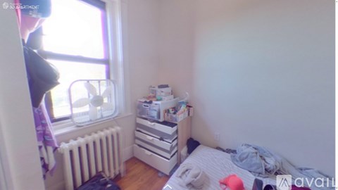 A small bedroom with a bed, dresser, and window.