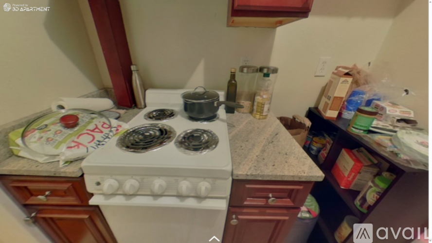 A white stove top oven with four burners is in a kitchen.