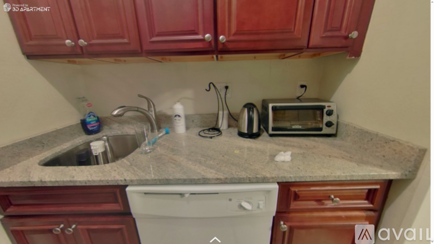 A kitchen with red cabinets and a granite countertop.