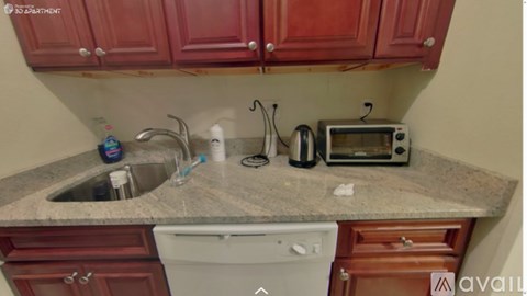 A kitchen with red cabinets and a granite countertop.