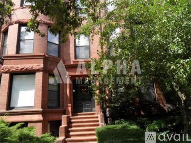 A red brick building with a black door and windows.