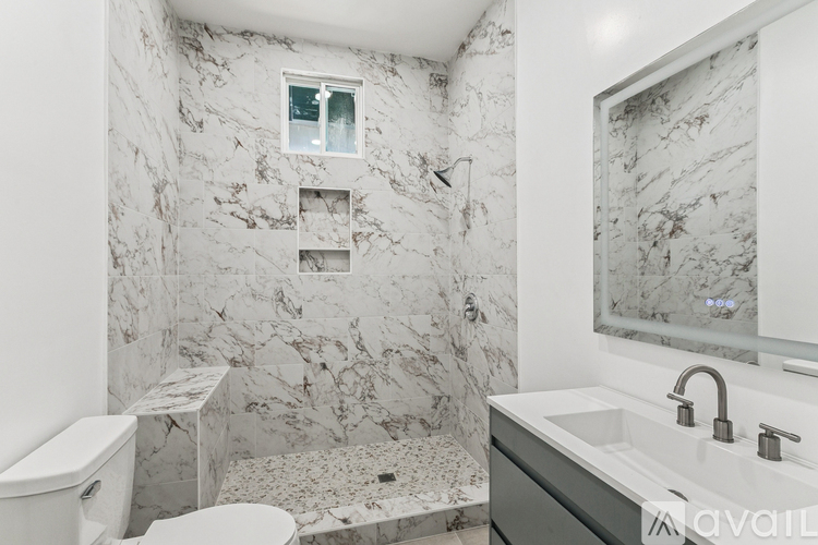 A bathroom with marble walls and a toilet.