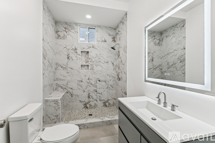A bathroom with marble walls and a white toilet.