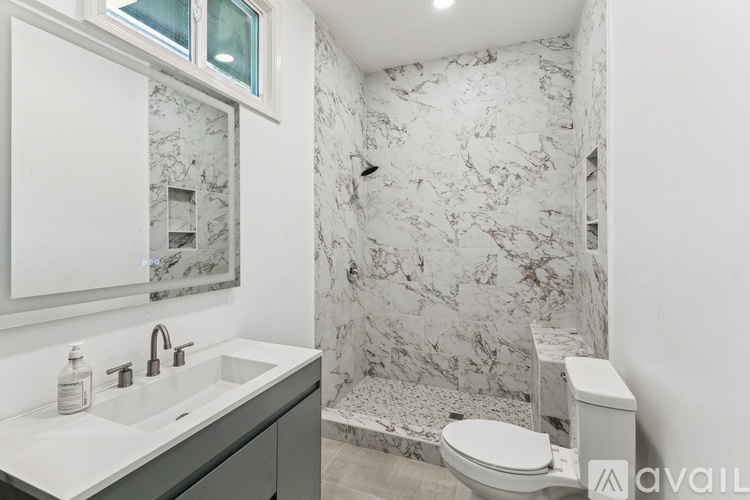 A bathroom with a marble wallpaper and a toilet.