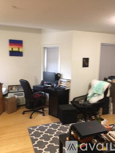 A room with a desk, chair, and a laptop on a table.