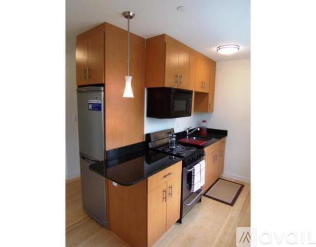 A kitchen with wooden cabinets and black countertops.