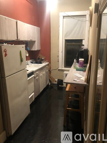 A kitchen with white appliances and wooden floors.