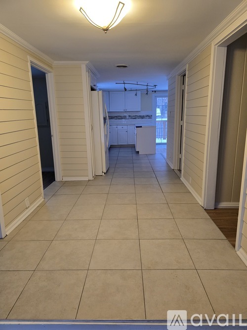 A long hallway with a tiled floor and white walls.