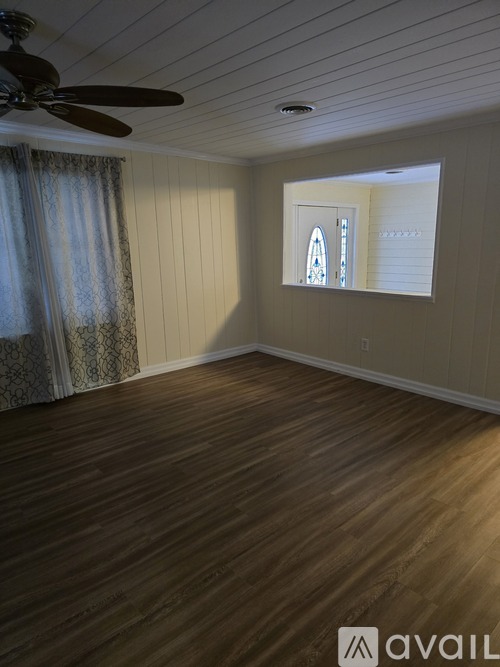 A room with wooden flooring and a ceiling fan.