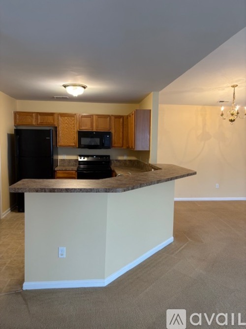 A kitchen with a black refrigerator and a black stove top oven.