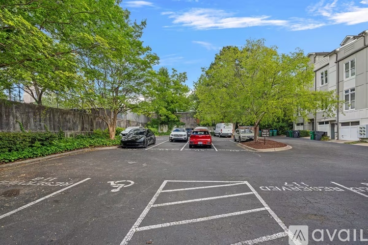 A parking lot with cars parked and trees in the background.