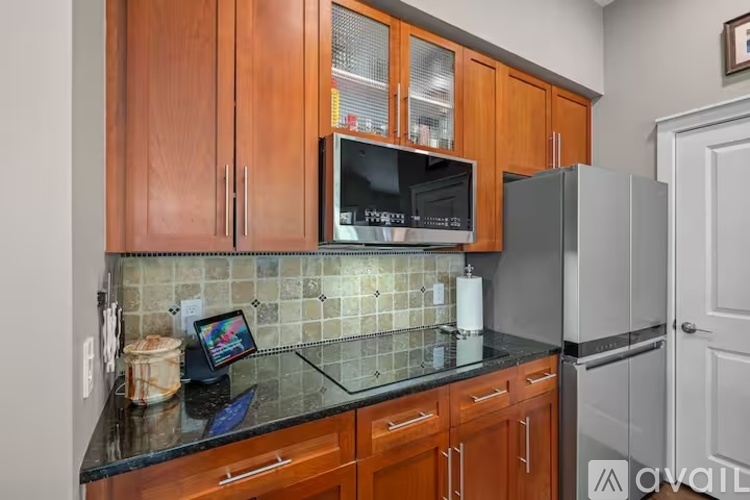 A kitchen with wooden cabinets and a black countertop.
