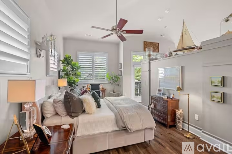 A bedroom with a large bed and a ceiling fan.