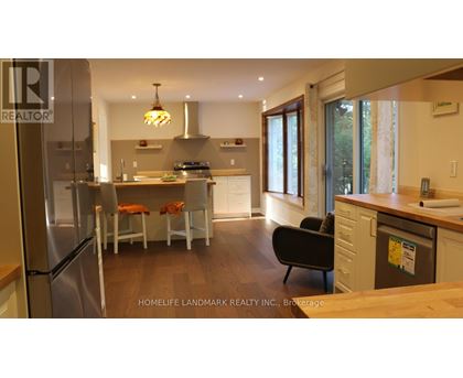 A modern kitchen with a refrigerator, sink, and dining table.