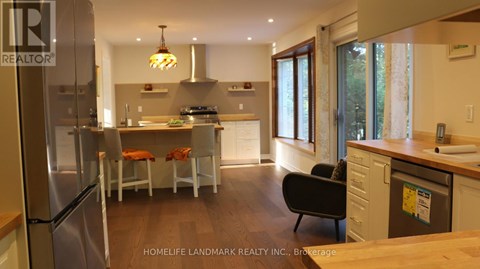 A modern kitchen with a refrigerator, sink, and dining table.