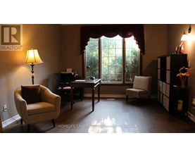 A living room with a chair, a desk, and a lamp.