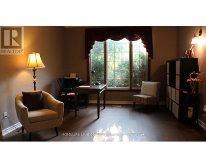 A living room with a chair, a desk, and a lamp.