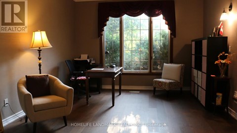A living room with a chair, a desk, and a lamp.