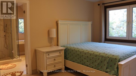 A bedroom with a bed, nightstand, and window.