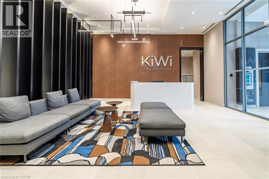 A modern living room with a grey sofa and a wooden wall with the words "Kiwi Condominiums" on it.