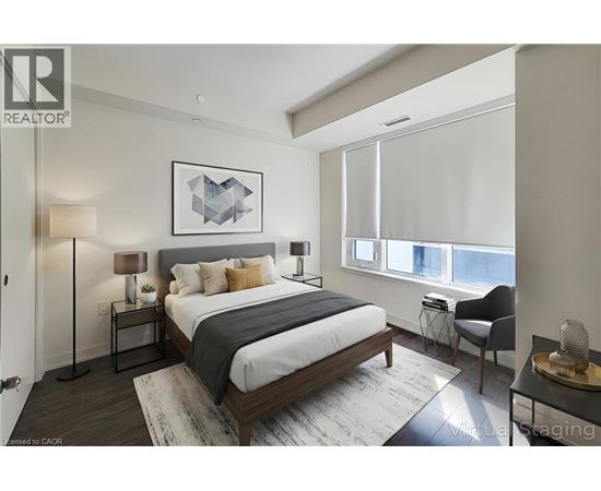 A bedroom with a large bed and a chair by the window.