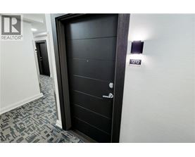 A spacious room with wooden flooring and a large window.