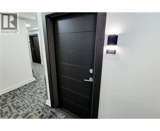 A spacious room with wooden flooring and a large window.