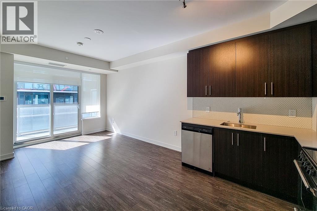 A modern kitchen with dark wood cabinets and stainless steel appliances.