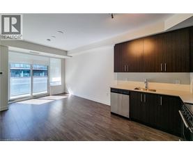 A modern kitchen with dark wood cabinets and stainless steel appliances.