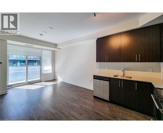 A modern kitchen with dark wood cabinets and stainless steel appliances.