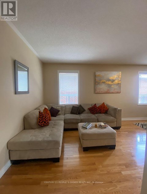 A living room with a grey couch and a small ottoman.