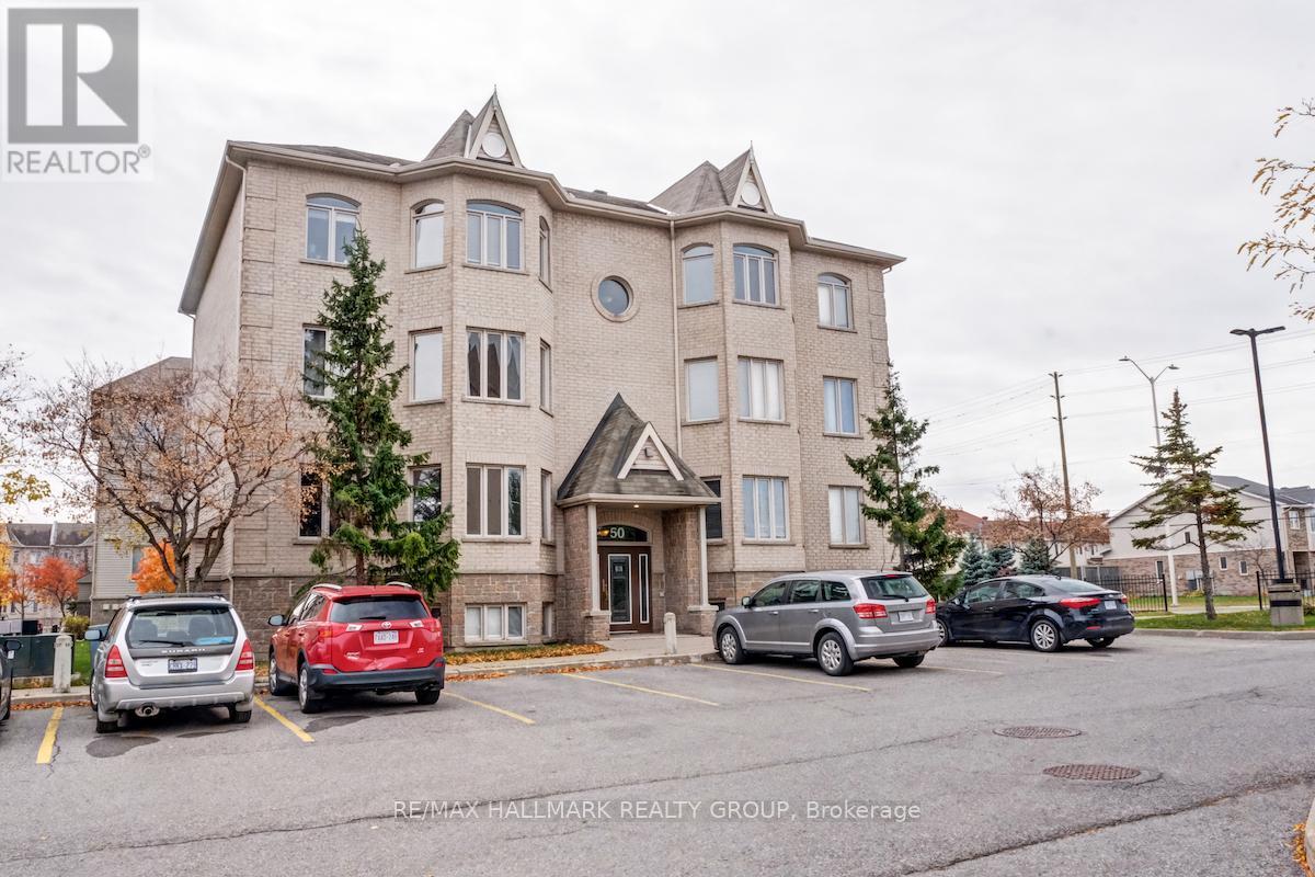 A large apartment building with a parking lot in front of it.