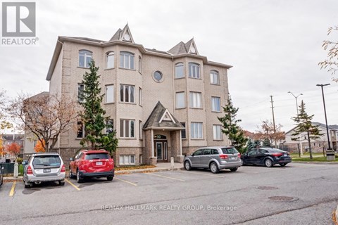 A large apartment building with a parking lot in front of it.