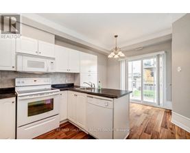 A kitchen with white appliances and cabinets.