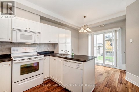 A kitchen with white appliances and cabinets.