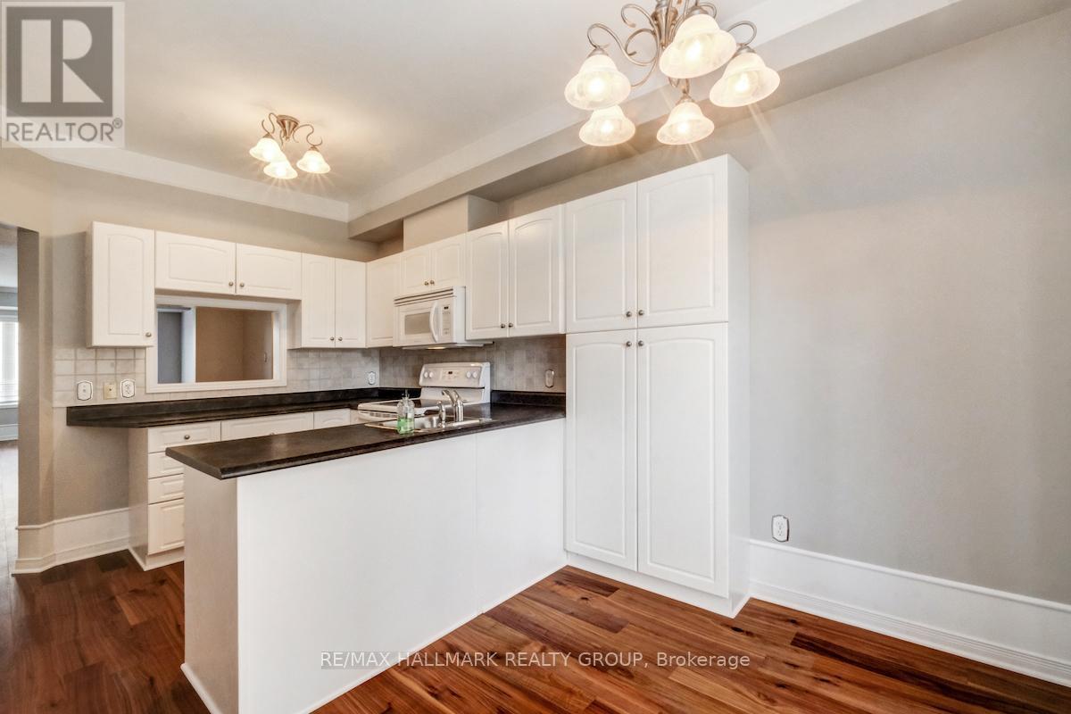 A kitchen with white cabinets and a black countertop.