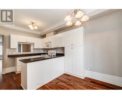 A kitchen with white cabinets and a black countertop.