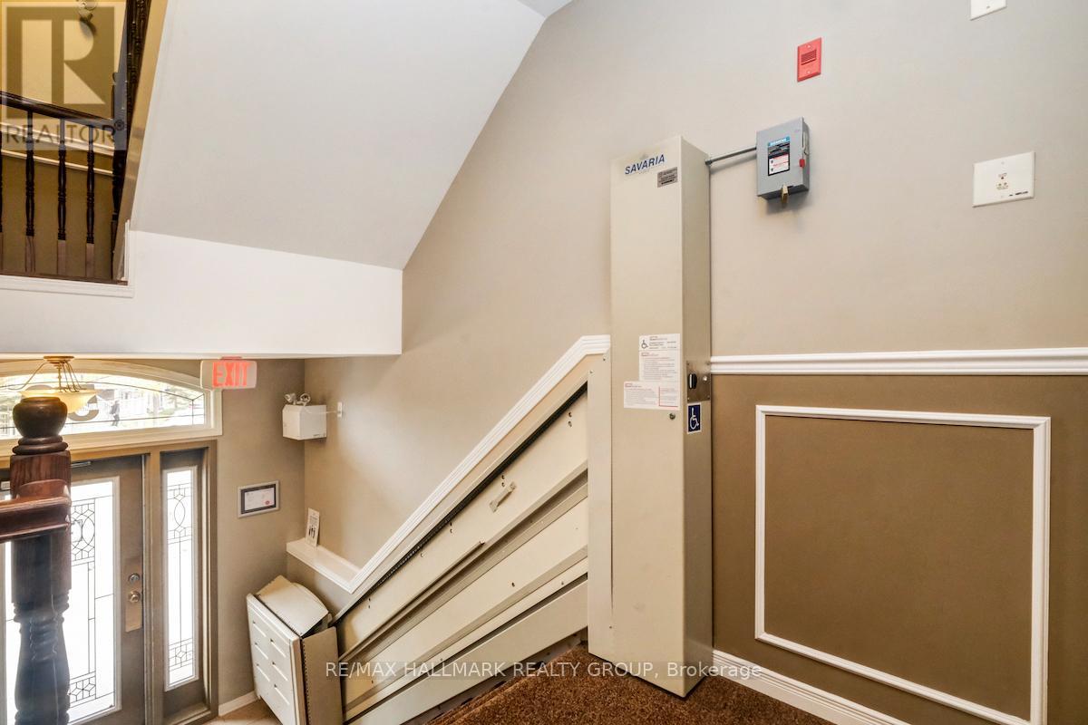 A hallway with a staircase and a wall-mounted elevator control panel.