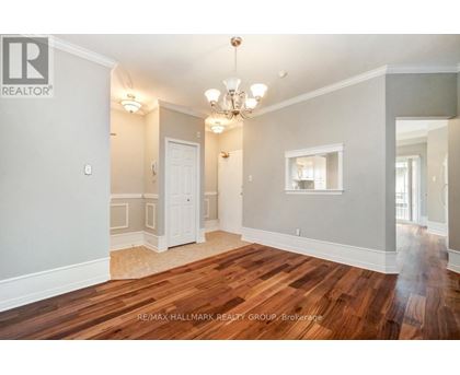 A spacious room with wooden floors and a chandelier.