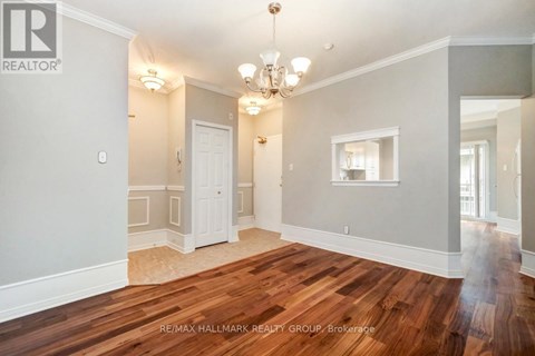 A spacious room with wooden floors and a chandelier.