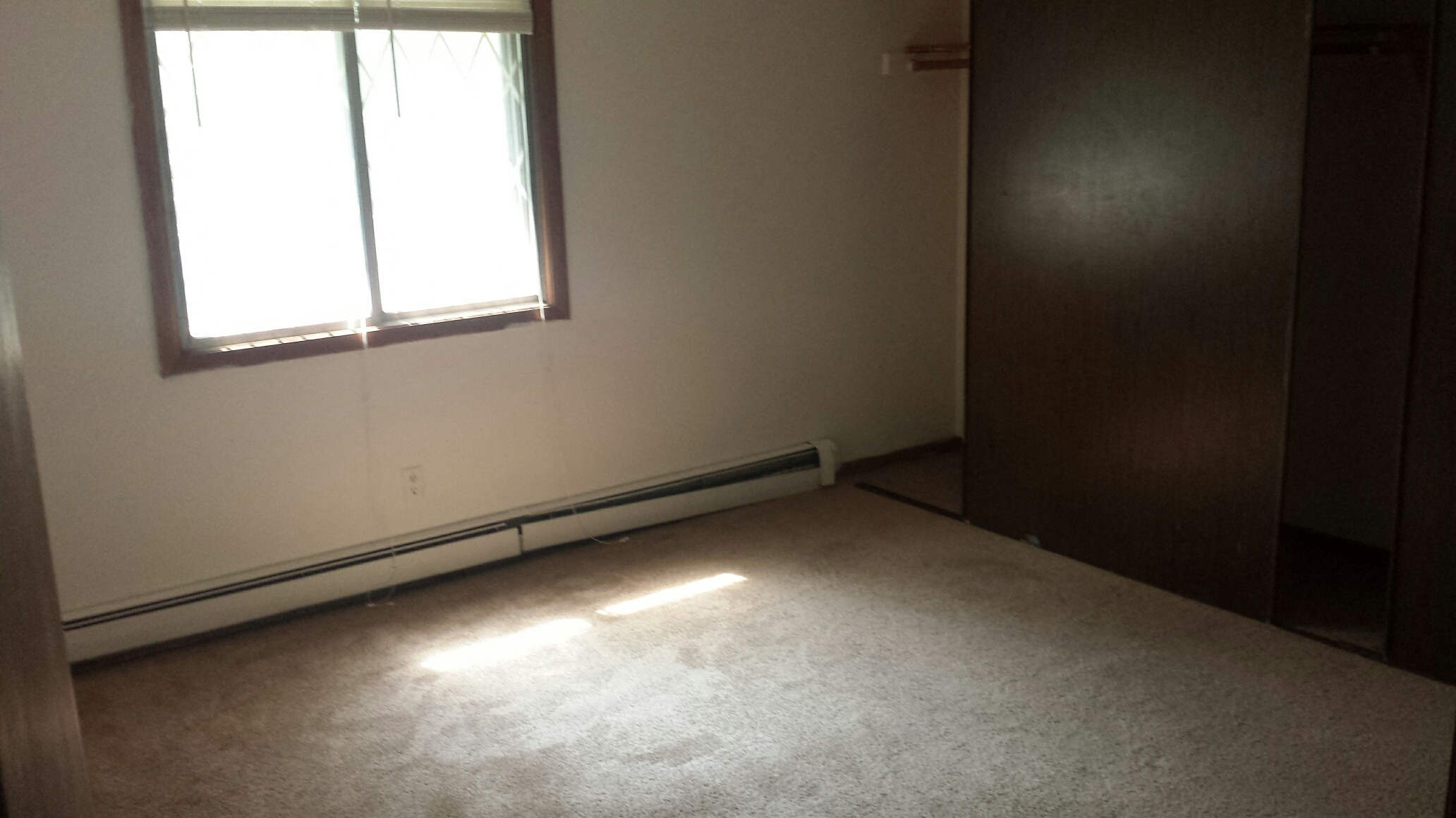 an empty room with a window and a door