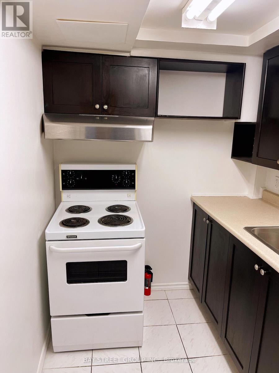 A white stove in a kitchen with black cabinets.