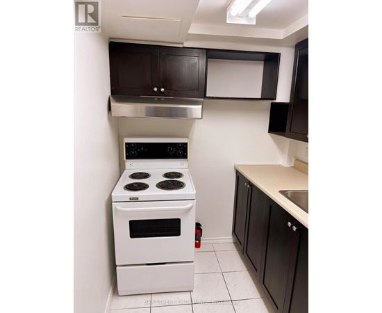 A white stove in a kitchen with black cabinets.